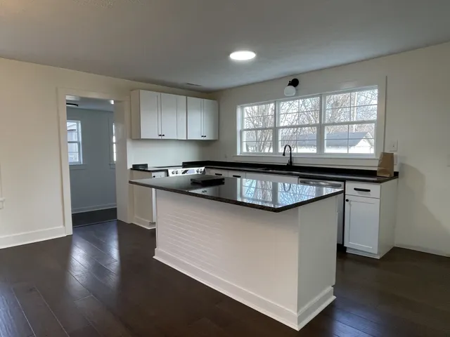 a kitchen with granite countertop a sink and a stove top oven