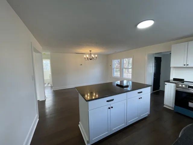 a kitchen with granite countertop a sink and cabinets