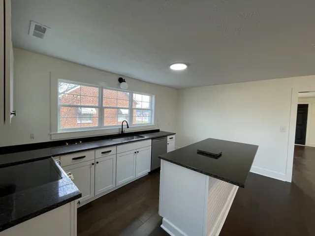 a kitchen that has a sink and a stove top oven
