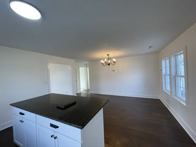 a kitchen with cabinets and wooden floor