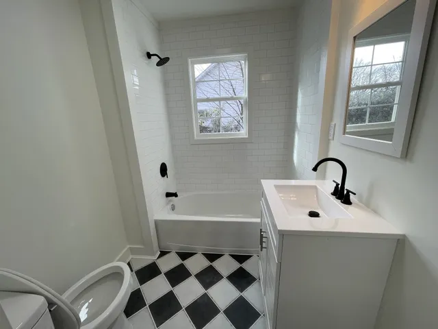 a bathroom with a sink a toilet and shower