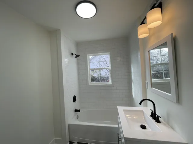 a bathroom with a sink mirror and vanity