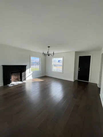 a view of empty room with window and wooden floor