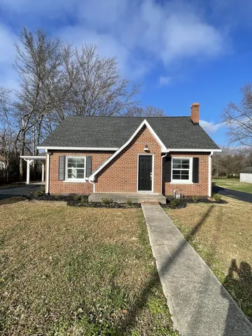 a view of house with a yard