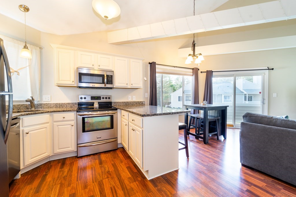 750 Whittenton Street, Unit 523 Taunton, MA 02780 - Photo 7 of 37 a kitchen with stainless steel appliances a stove top oven a sink a dining table and chairs