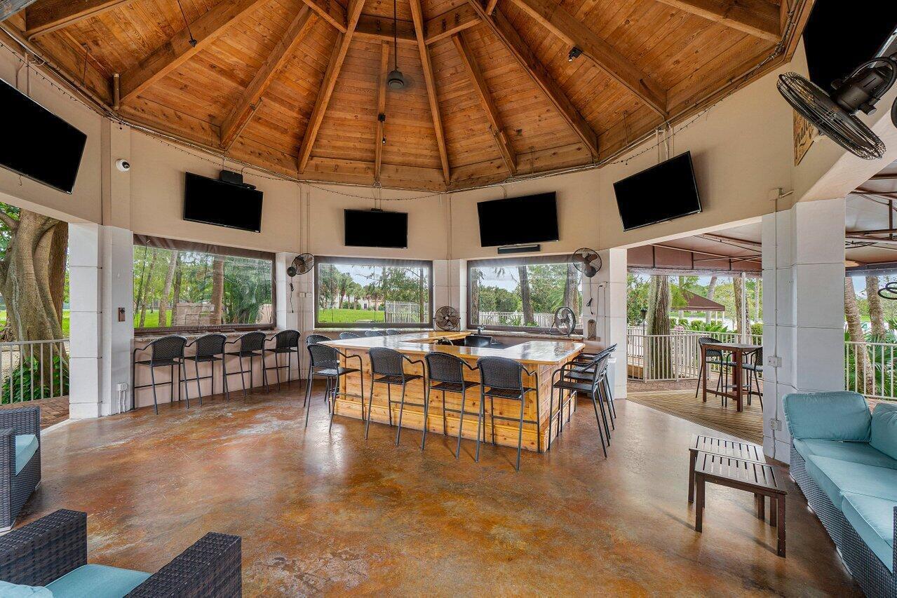 10821 La Salinas Circle Boca Raton, FL 33428 - Photo 57 of 64 a living room with furniture a flat screen tv and floor to ceiling windows