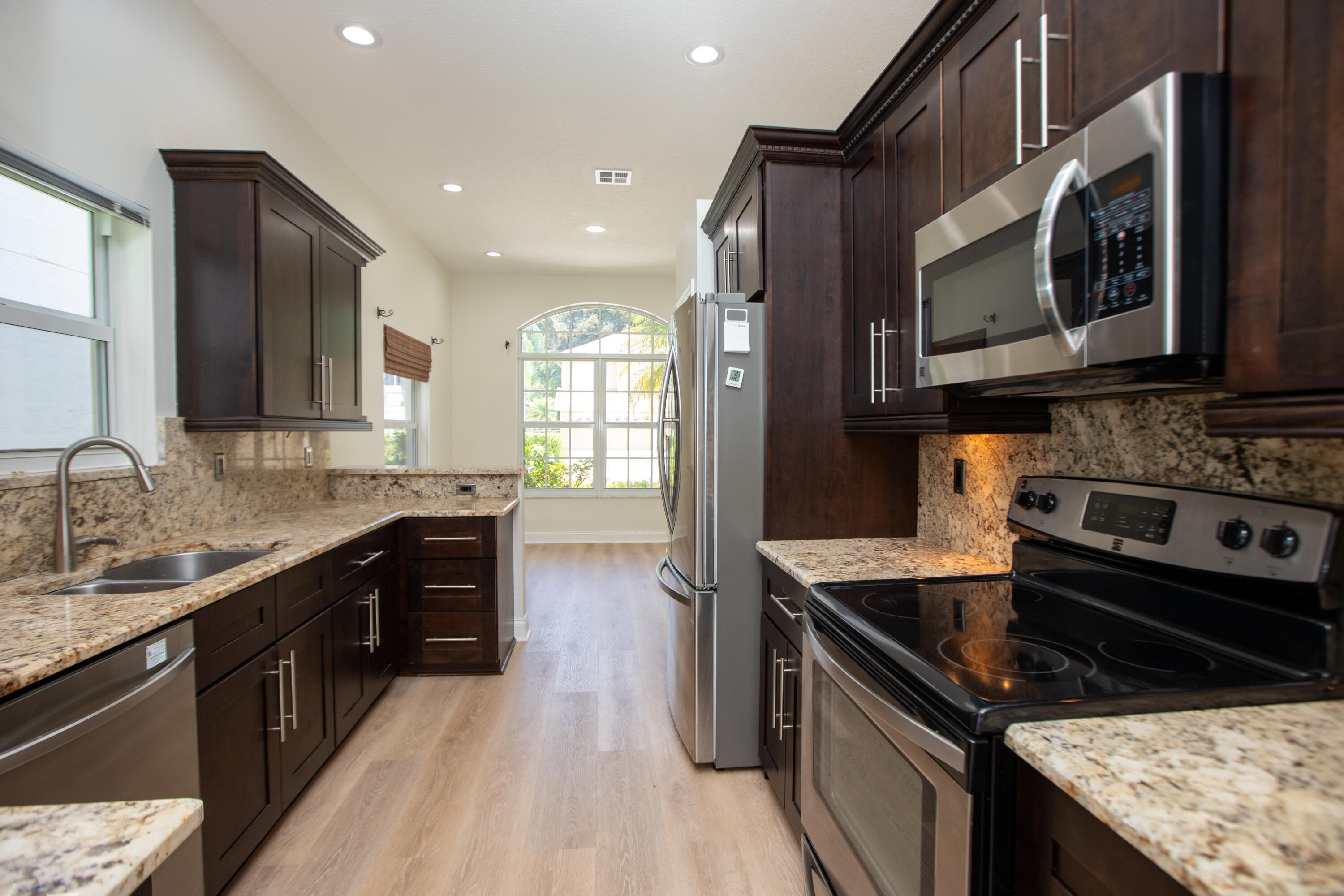 10821 La Salinas Circle Boca Raton, FL 33428 - Photo 7 of 64 a kitchen with stainless steel appliances granite countertop a stove a sink and a microwave