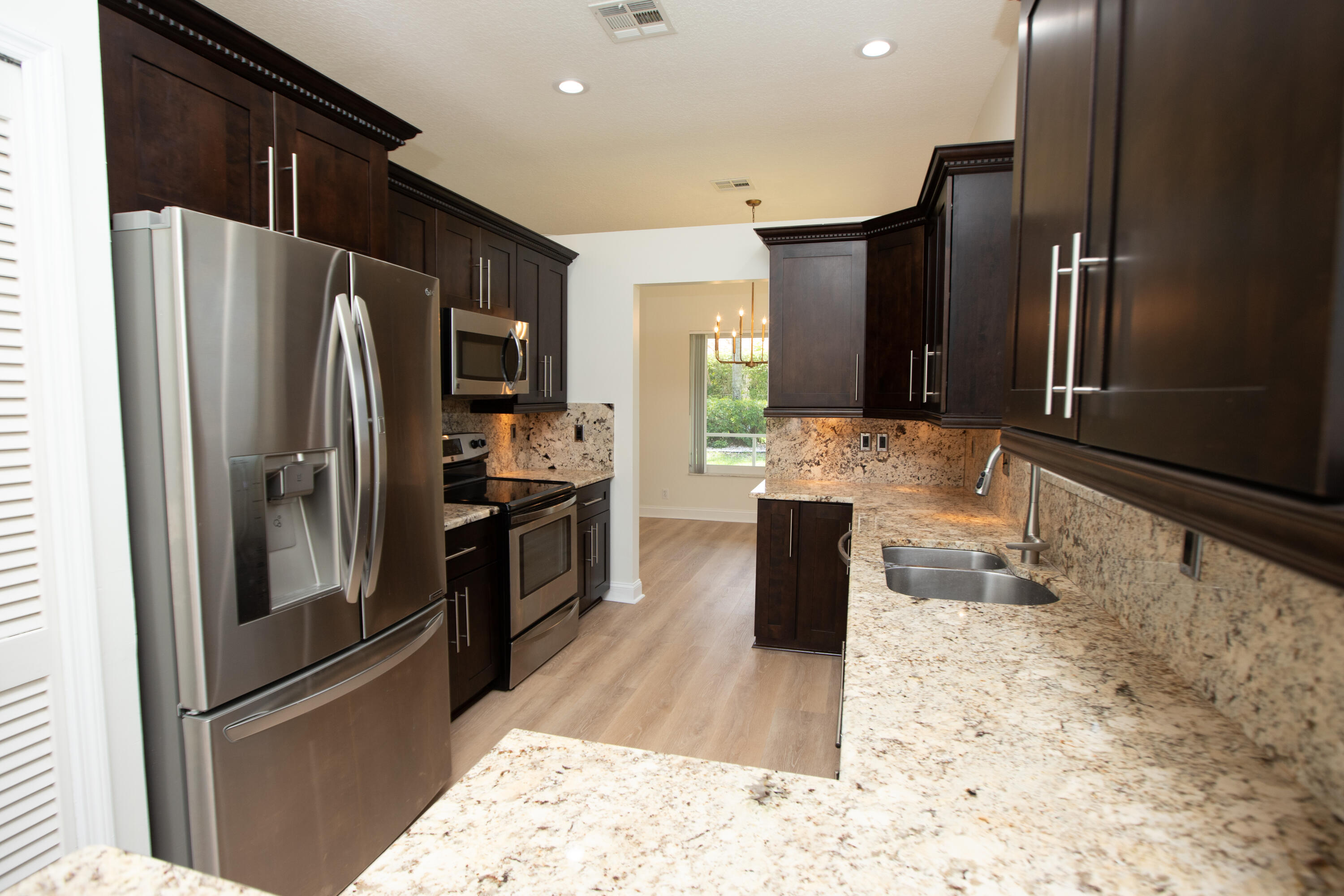 10821 La Salinas Circle Boca Raton, FL 33428 - Photo 8 of 64 a large kitchen with stainless steel appliances kitchen island granite countertop a refrigerator and a sink