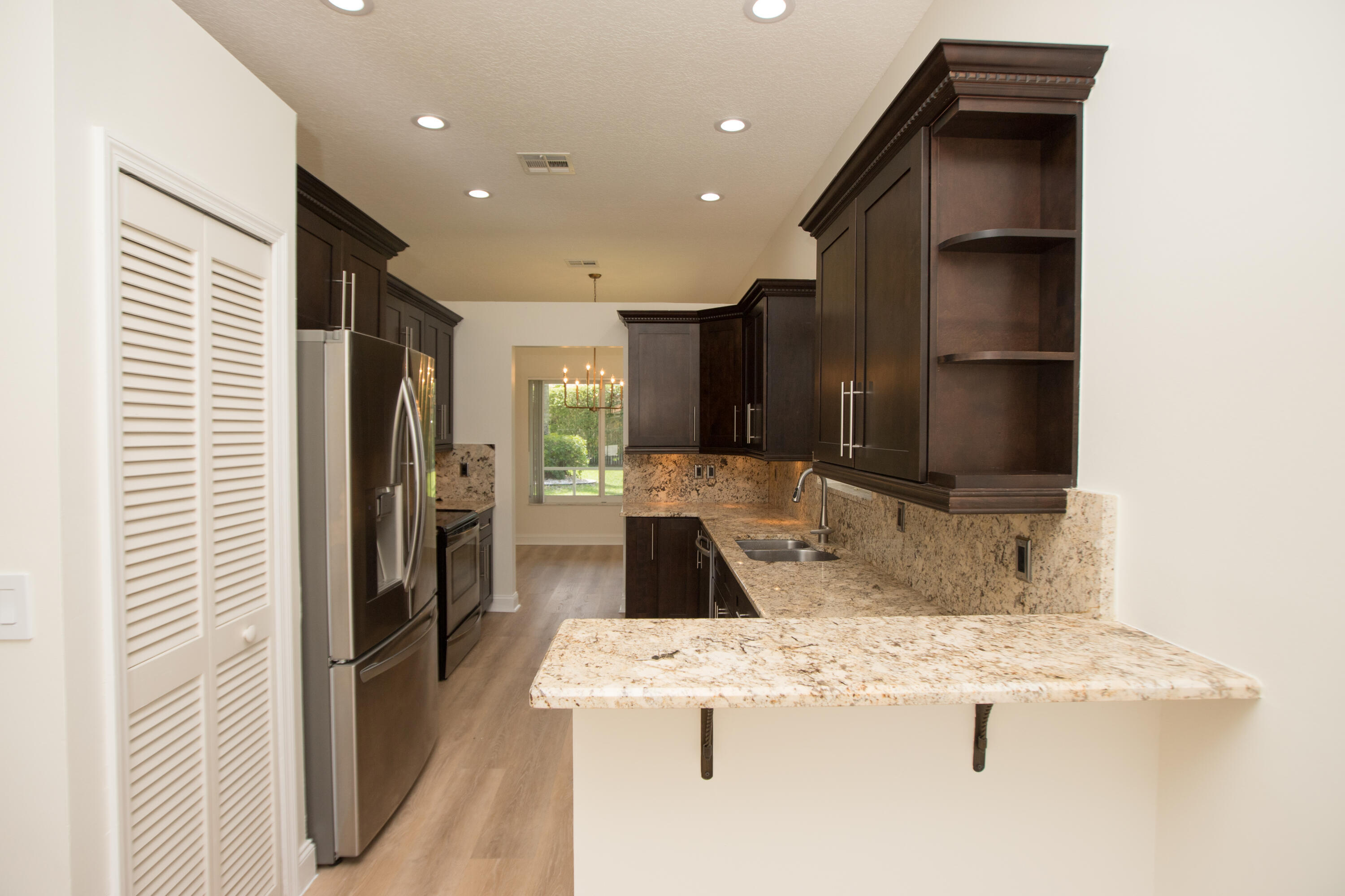 10821 La Salinas Circle Boca Raton, FL 33428 - Photo 10 of 64 a kitchen with kitchen island granite countertop a refrigerator and a sink