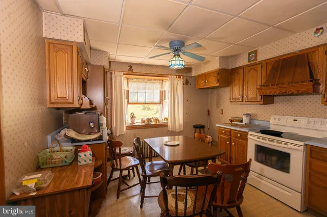 a kitchen with stainless steel appliances a table chairs and a stove