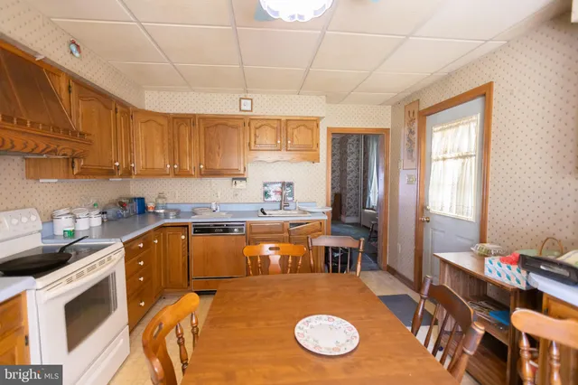 a kitchen with a table chairs sink and cabinets
