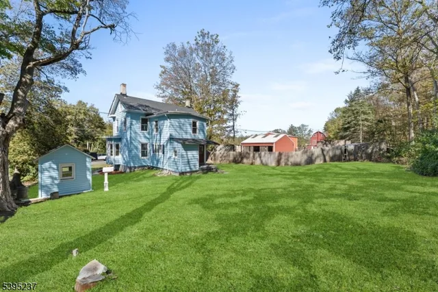 a view of a house with a yard and large tree