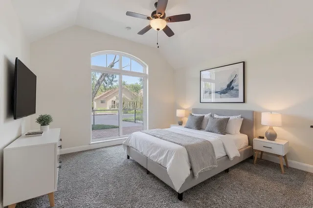 an empty room with windows and fan