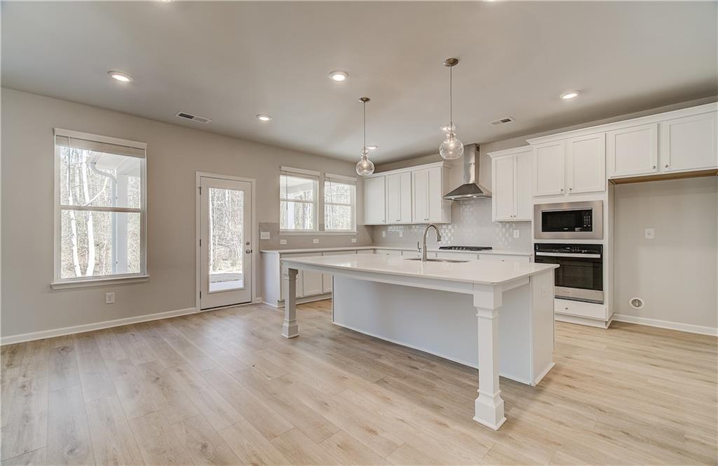 228 Ruthe Cove Locust Grove, GA 30248 - Photo 13 of 31 a kitchen with white cabinets and window