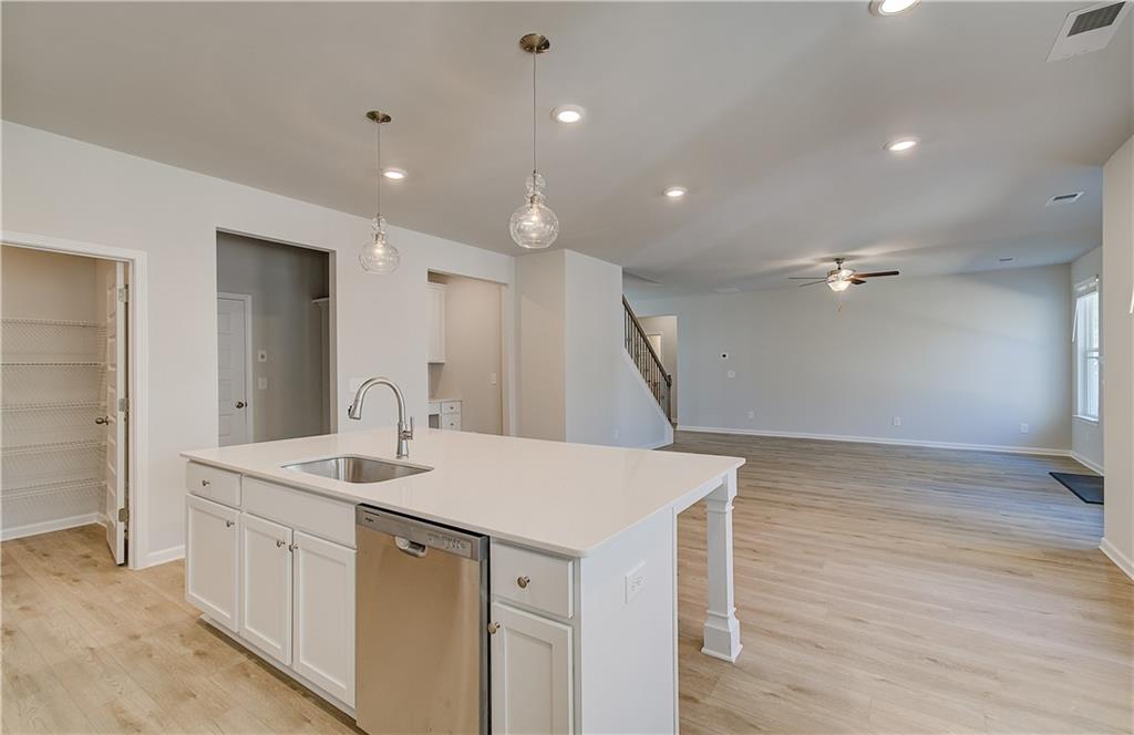228 Ruthe Cove Locust Grove, GA 30248 - Photo 15 of 31 a kitchen with a sink appliances and a wooden floor