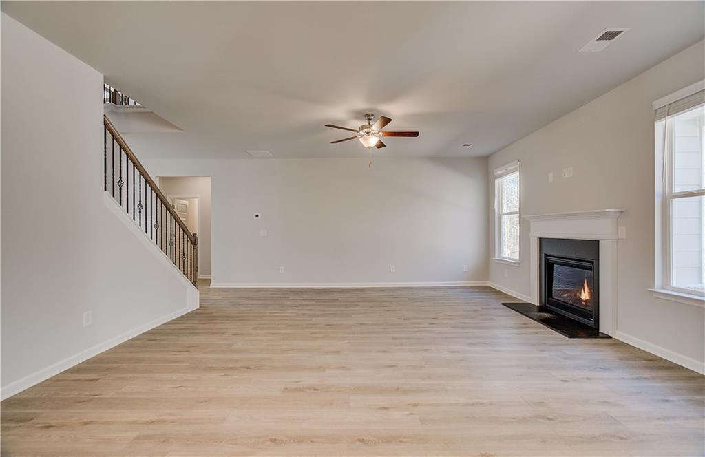 228 Ruthe Cove Locust Grove, GA 30248 - Photo 16 of 31 a view of an empty room with wooden floor fireplace and a window