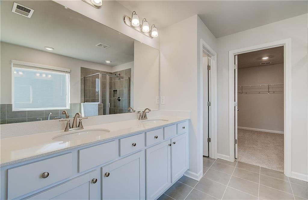 228 Ruthe Cove Locust Grove, GA 30248 - Photo 26 of 31 a bathroom with double sink and a mirror