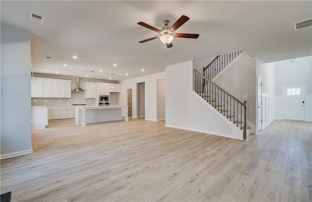 228 Ruthe Cove Locust Grove, GA 30248 - Photo 10 of 31 a view of a livingroom with a ceiling fan wooden floor and a ceiling fan