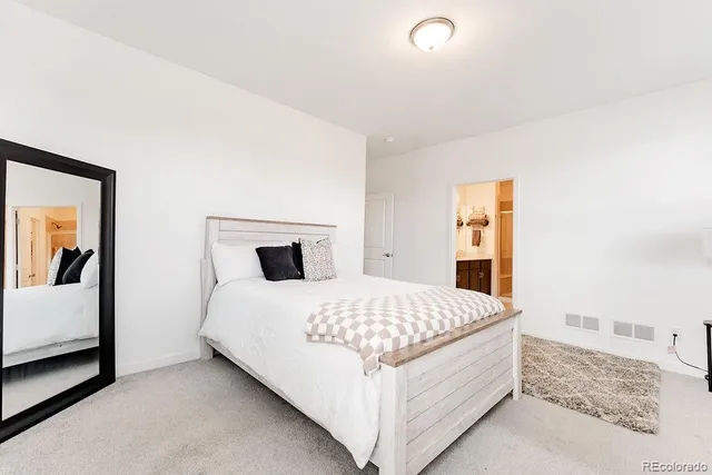 a bedroom with a bed and a painting on the wall