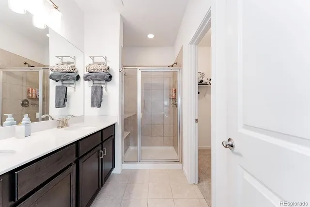 a bathroom with a double vanity sink mirror and shower