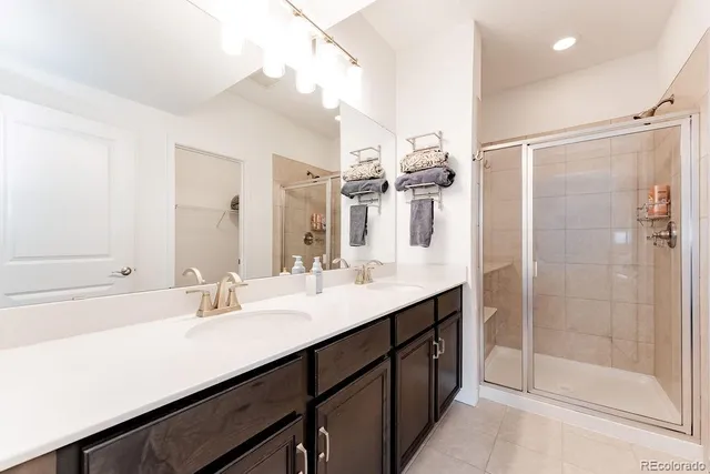 a bathroom with a double vanity sink mirror and shower