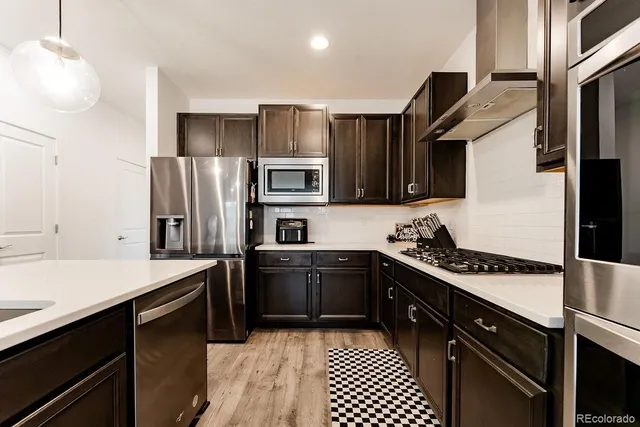 a kitchen with stainless steel appliances a sink stove and refrigerator