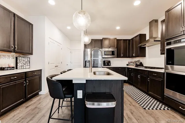 a kitchen with stainless steel appliances kitchen island granite countertop a sink stove and refrigerator
