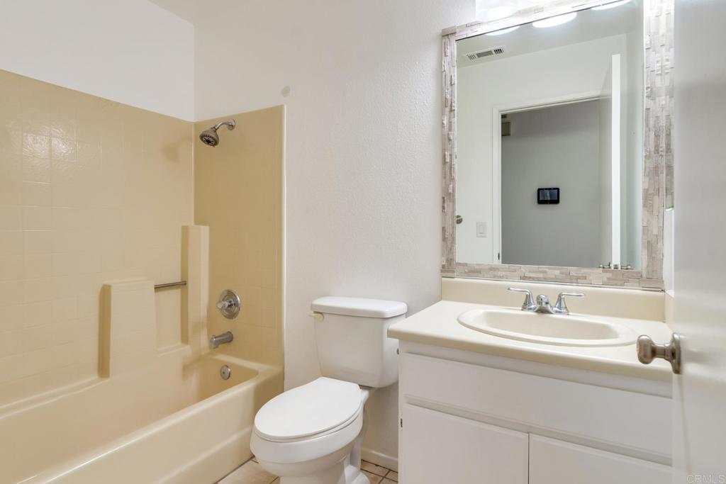 4791 Macadamia Court Oceanside, CA 92057 - Photo 11 of 20 a bathroom with a granite countertop sink a toilet and shower