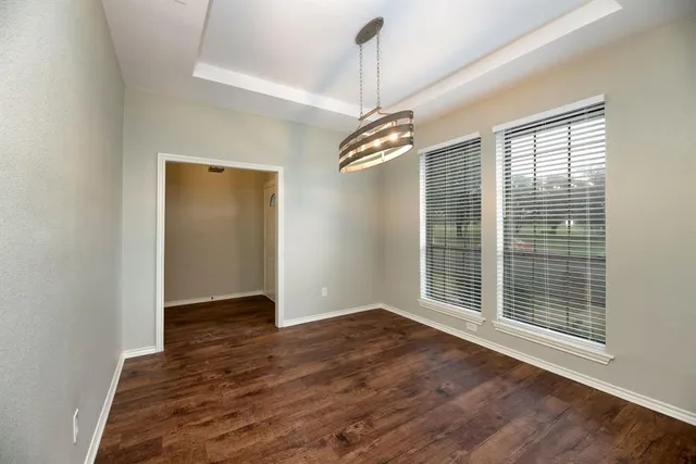 a view of an empty room with wooden floor fireplace and a window