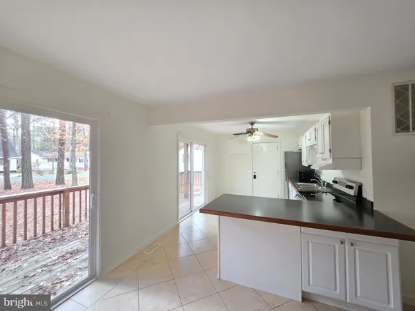 a large white kitchen with a sink and dishwasher a stove with wooden floors