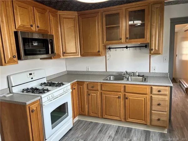 a kitchen with granite countertop cabinets stainless steel appliances and wooden floor