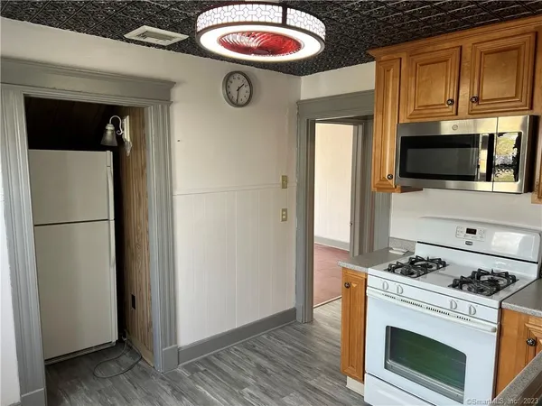 a view of kitchen with stainless steel appliances granite countertop a stove top oven a refrigerator with wooden floor