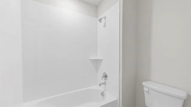 a white bath tub sitting next to a white toilet