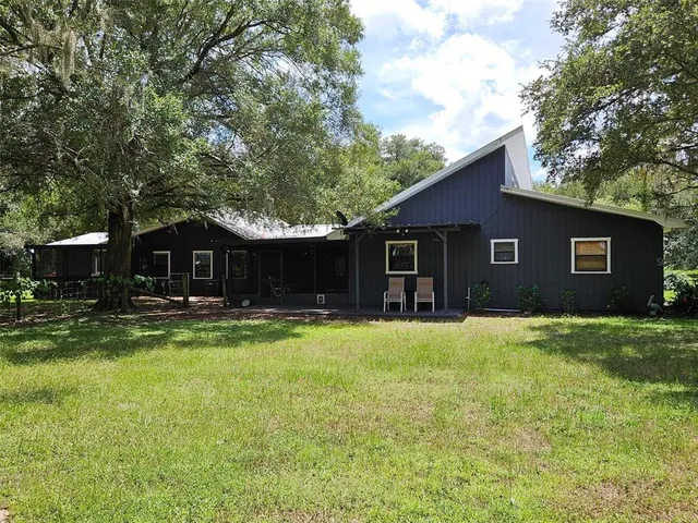 a view of a house with a yard and a tree