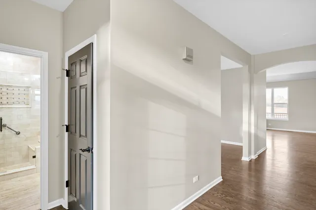 a view of an empty room with wooden floor and a glass door