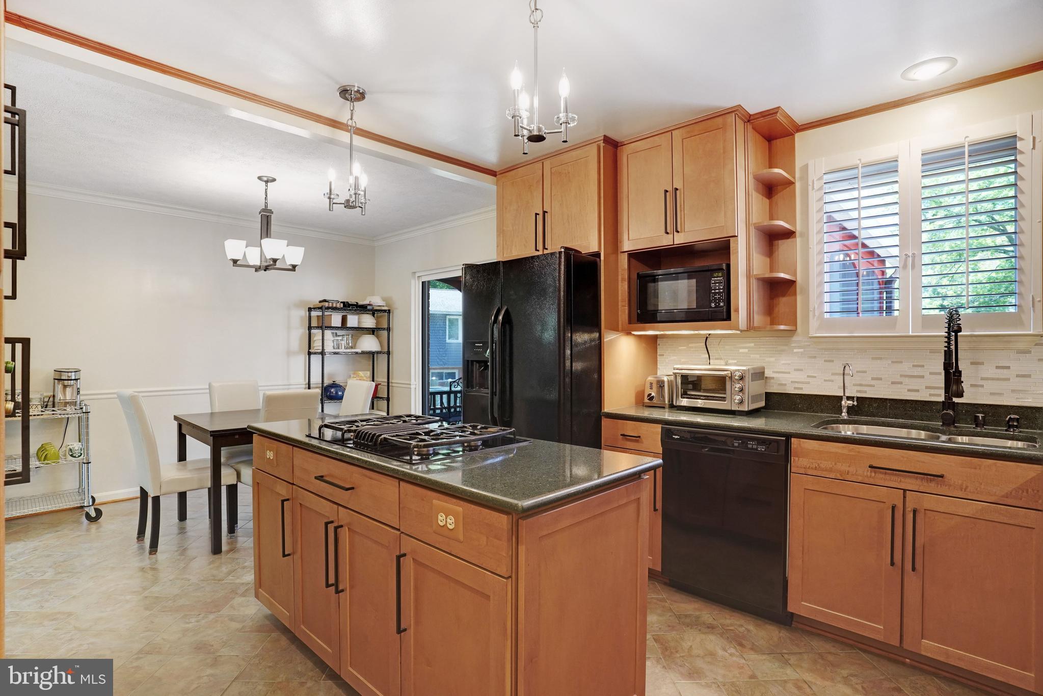 5300 Kings Park Drive Springfield, VA 22151 - Photo 17 of 62 a kitchen with stainless steel appliances granite countertop a stove a sink dishwasher a refrigerator and a dining table with wooden cabinet