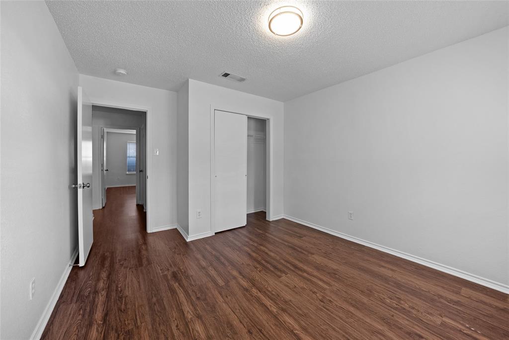 2910 Chisholm Trail Corinth, TX 76210 - Photo 23 of 30 a view of an empty room with wooden floor and a window