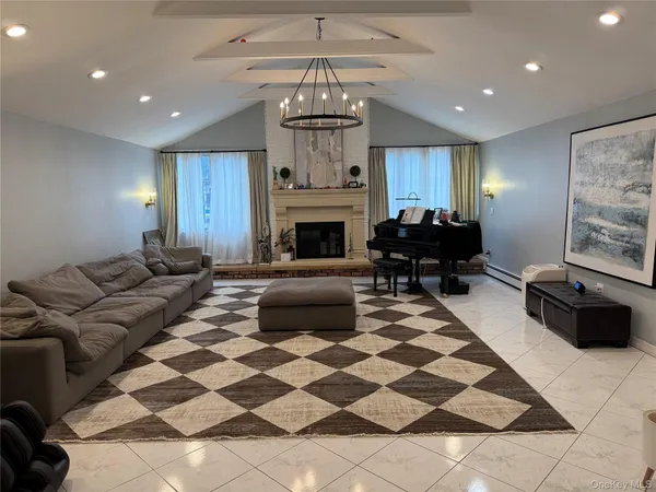 a living room with furniture a fireplace and a chandelier