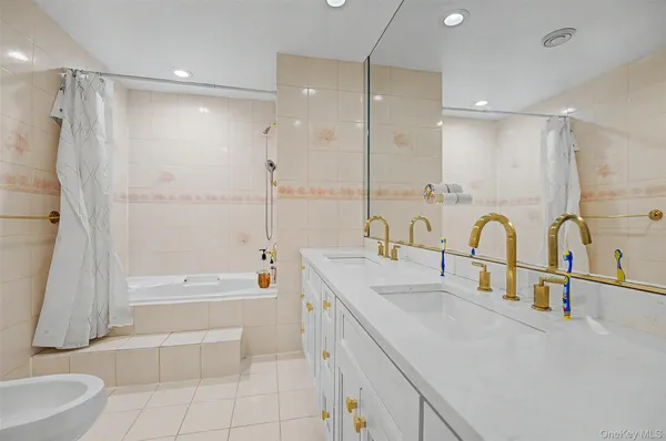 a bathroom with a double vanity sink a toilet and shower