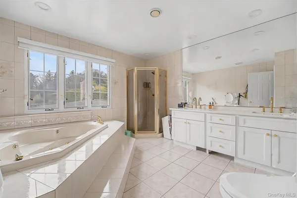 a spacious bathroom with a tub sink and mirror