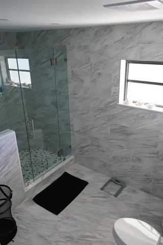 a bathroom with a toilet a sink and shower