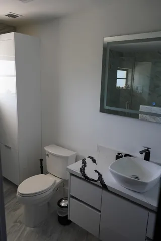 a bathroom with a toilet sink and mirror