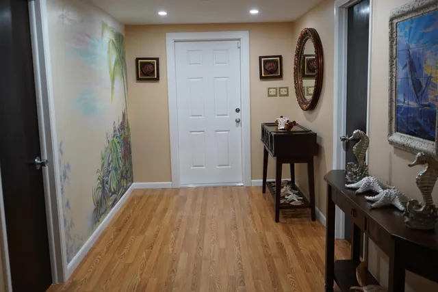 a view of a hallway with wooden floor and furniture