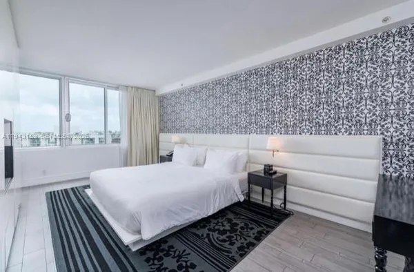 a bedroom with a large bed and a window