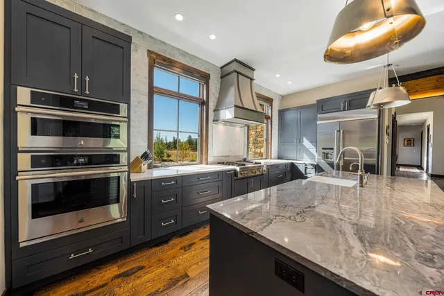 a kitchen with stainless steel appliances granite countertop a stove a sink and a microwave