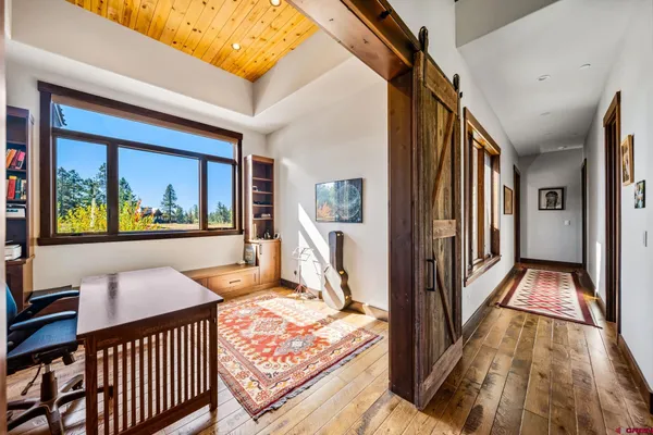a view of a hallway and wooden floor and dining room