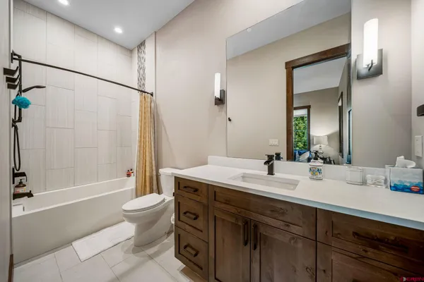 a bathroom with a double vanity sink toilet mirror and bathtub
