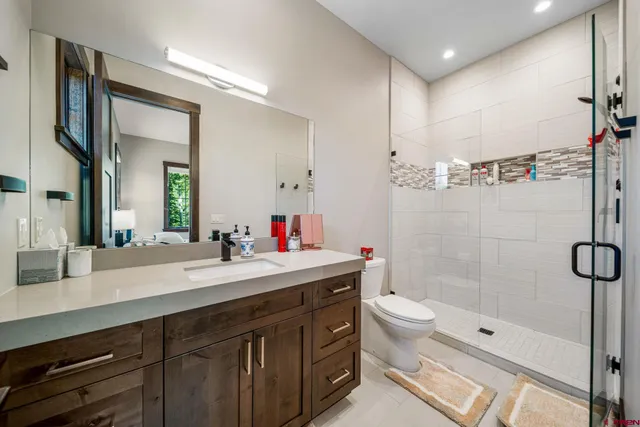 a bathroom with a sink a toilet and shower