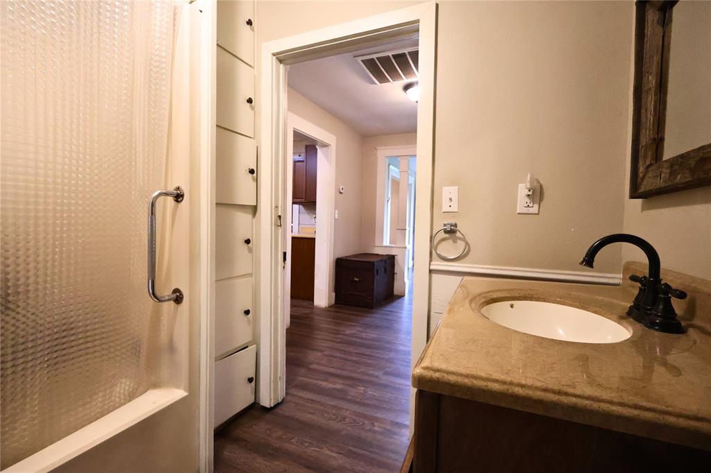 210 Hopkins Street Alba, TX 75410 - Photo 18 of 36 Bathroom featuring wood finished floors, vanity, and shower / bath combo with shower curtain