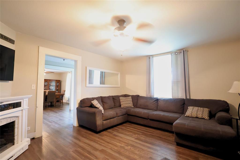 210 Hopkins Street Alba, TX 75410 - Photo 27 of 36 Living area featuring ceiling fan, wood finished floors, and a high end fireplace